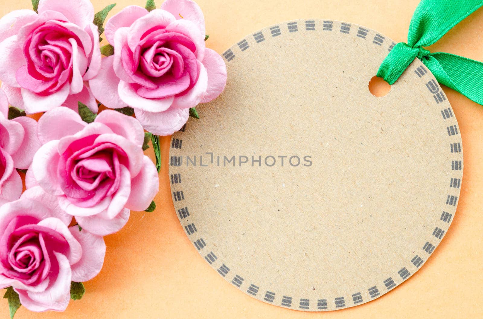 Blank brown paper tag and pink rose for your text. by Gamjai