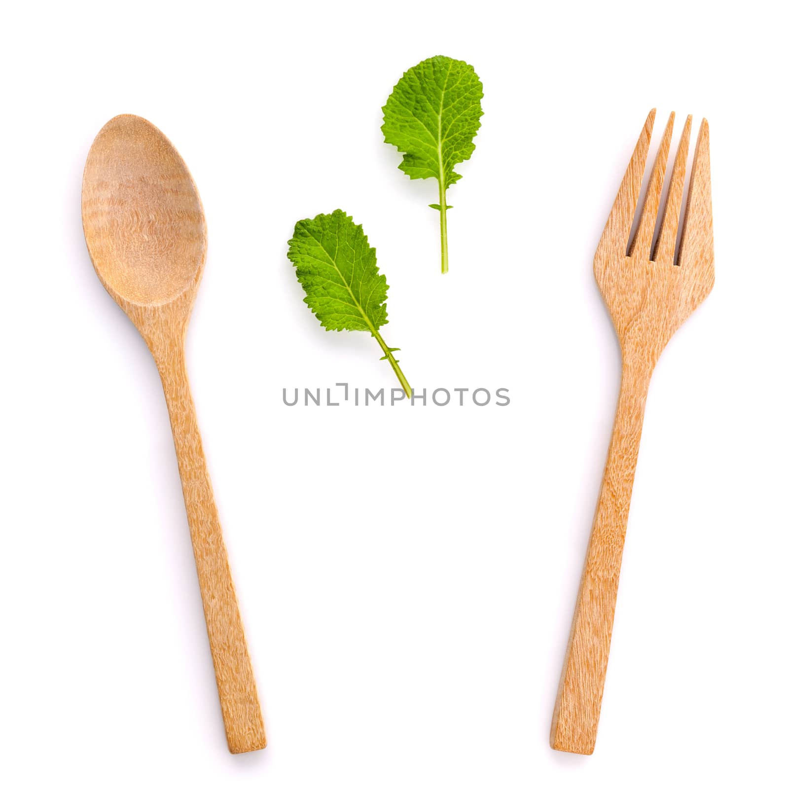 Healthy food concept fresh organic green leaves with wooden fork and spoon isolated on white background cutout .