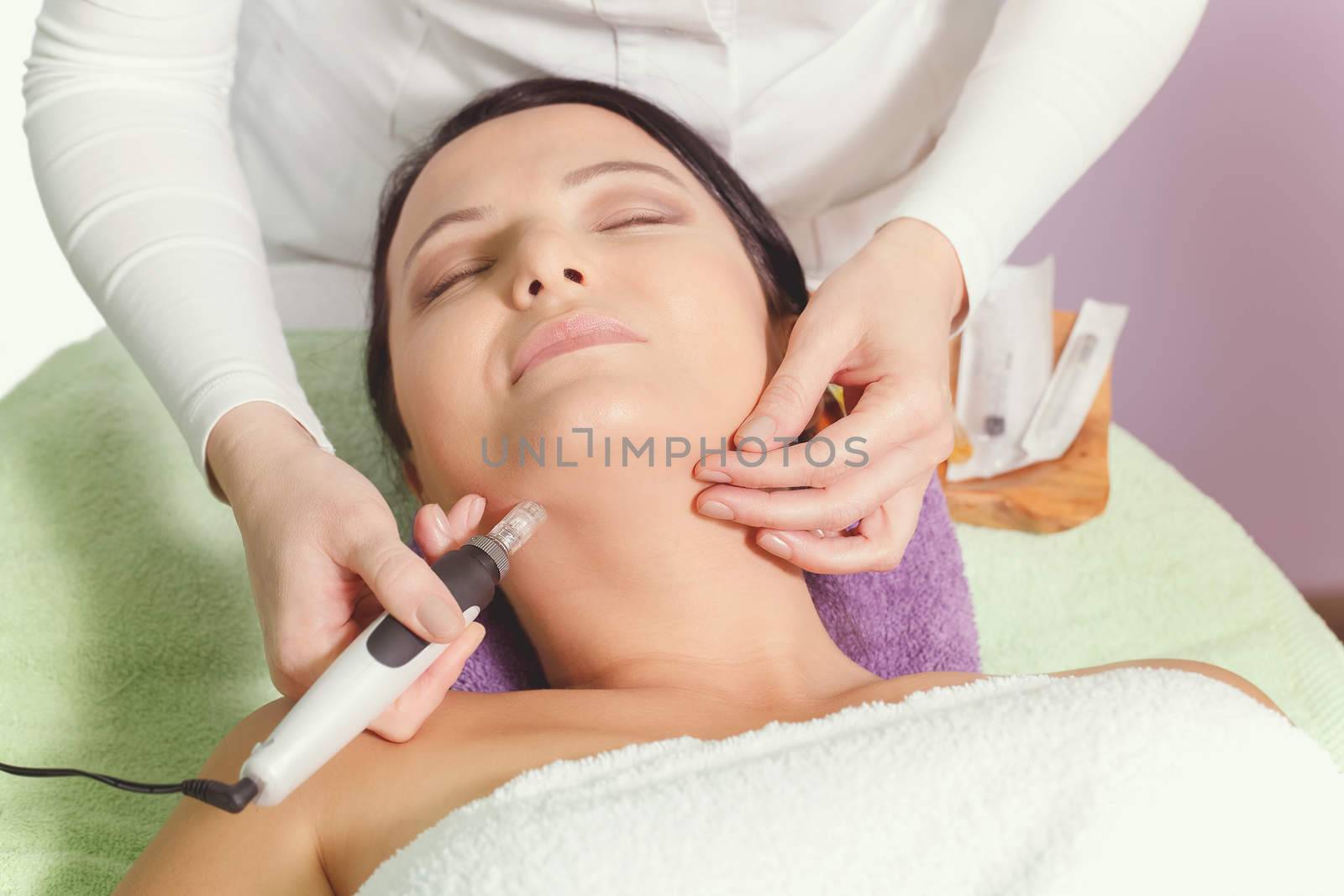 Woman having mesotherapy facial treatment at beauty salon