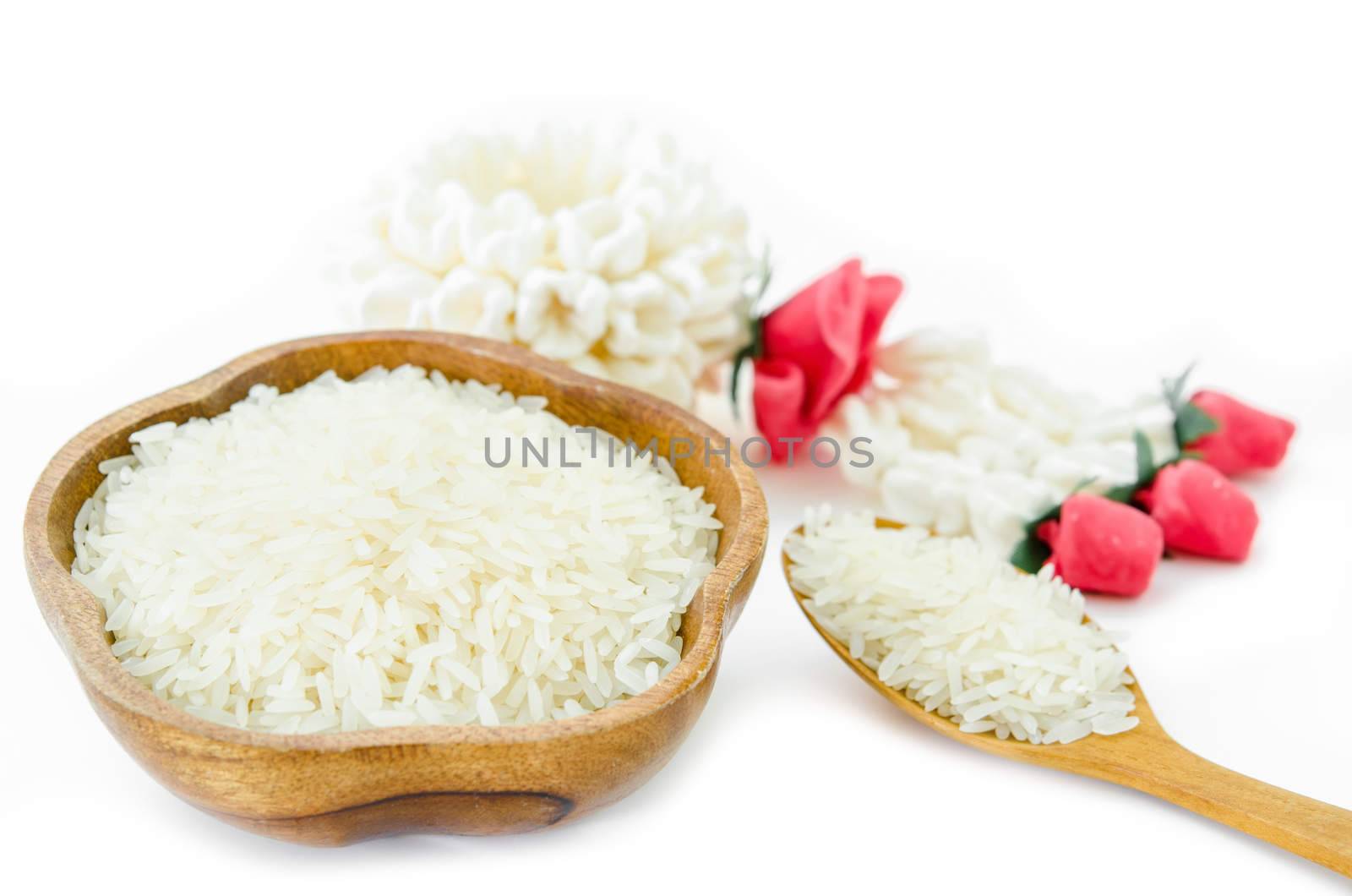 Raw white rice from Thailand in wooden bowl and spoon on white background.