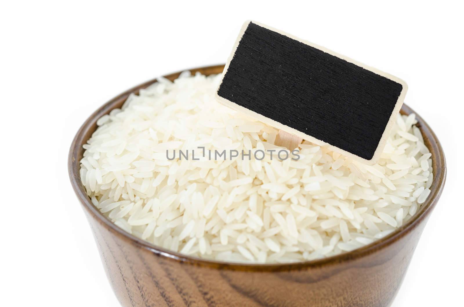 Raw rice and black wooden tag. by Gamjai