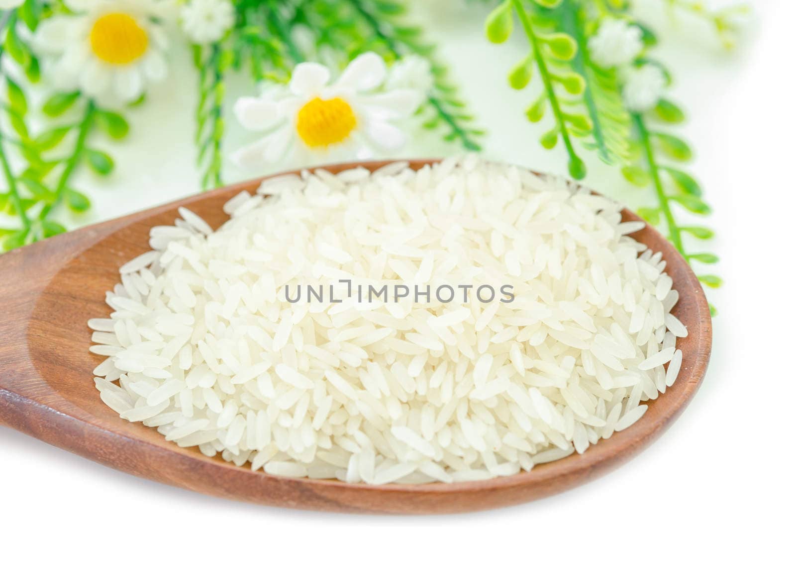 Jasmine rice in wooden spoon and white flower on white background.