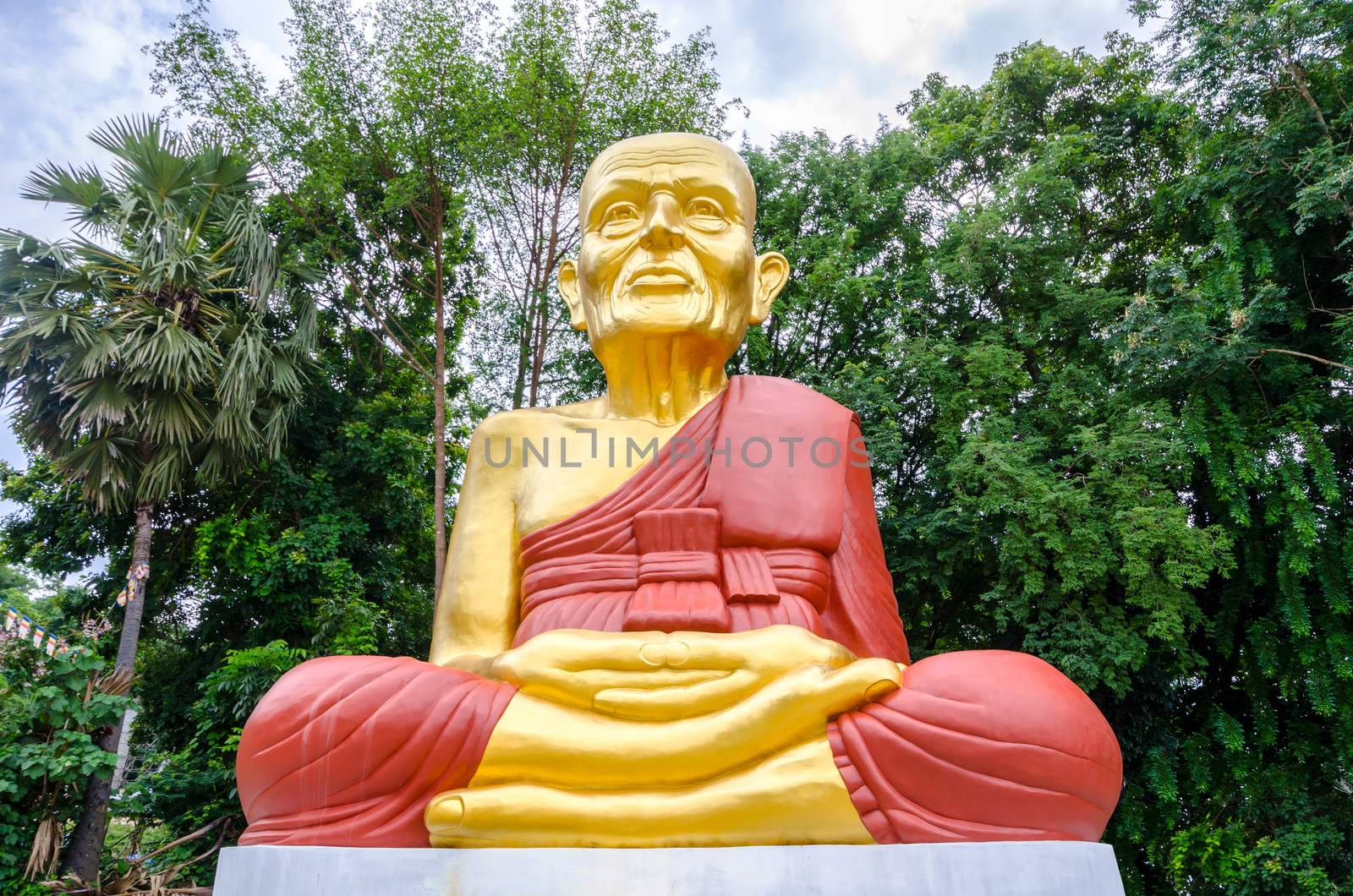 Big Buddha statue and big trees in garden.