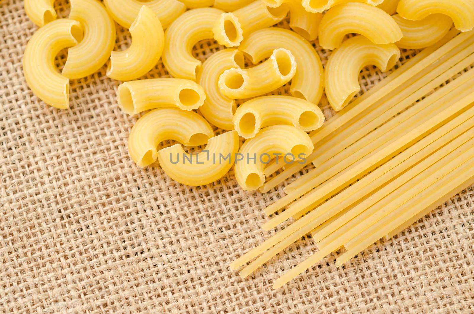 Raw Spaghetti Macaroni. Italian Pasta raw food collection on sack background.