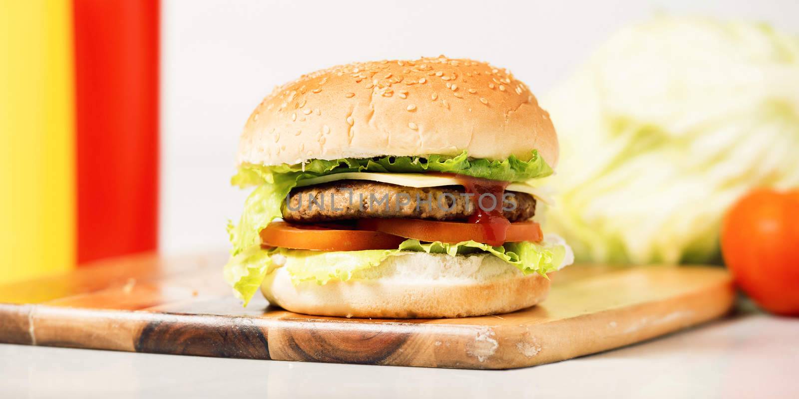 Hamburger with cheese and ingredients with a white background and timber board.