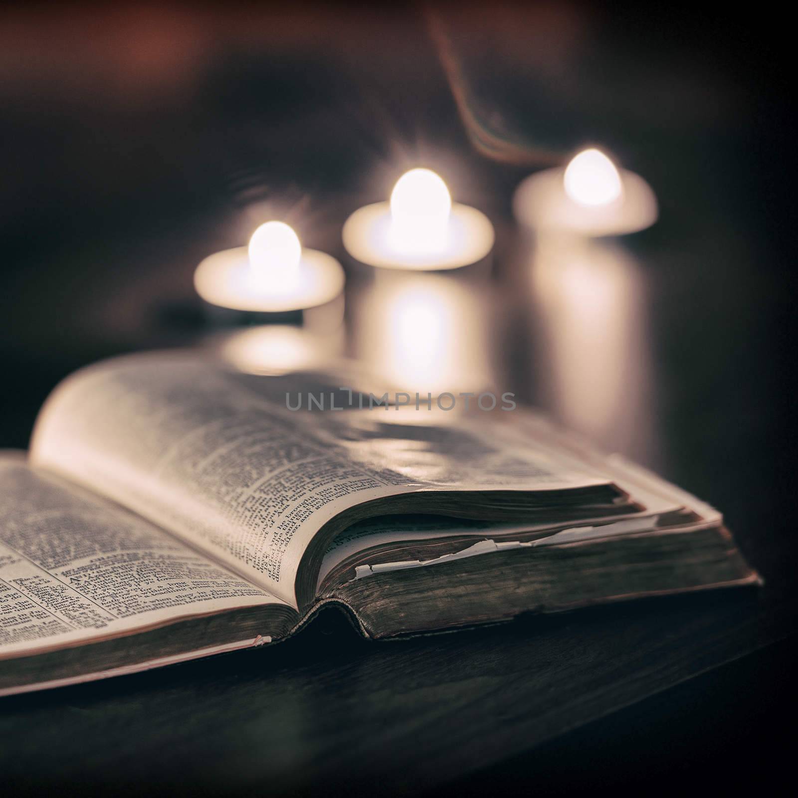 Bible with candles in the background. Low light scene.