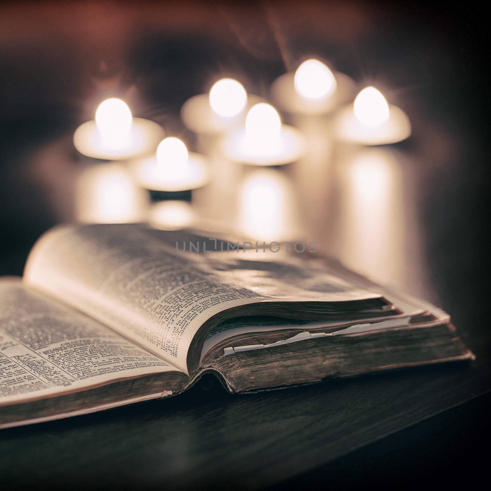 Bible with candles in the background. Low light scene.