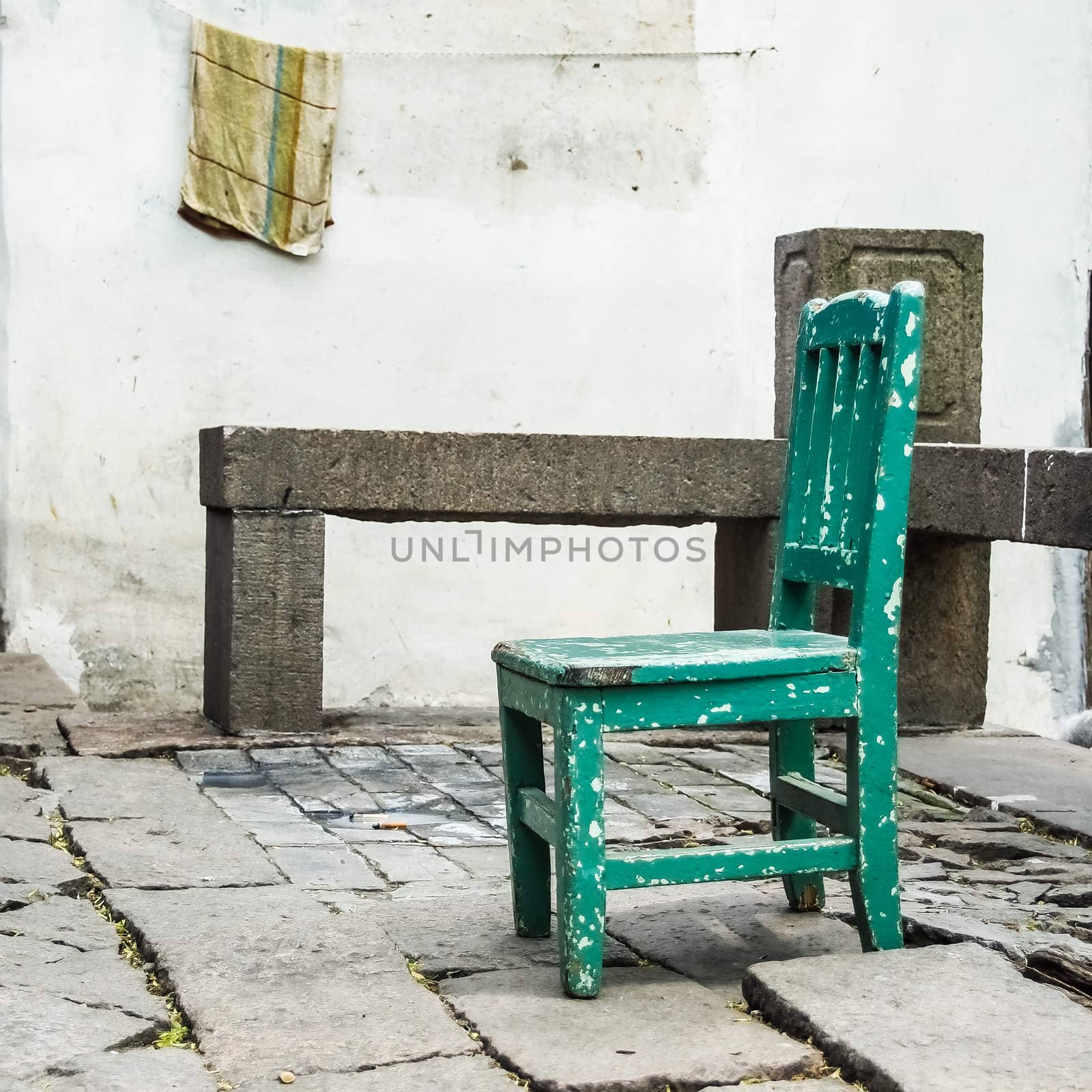 old grunge small green wooden chair in the village