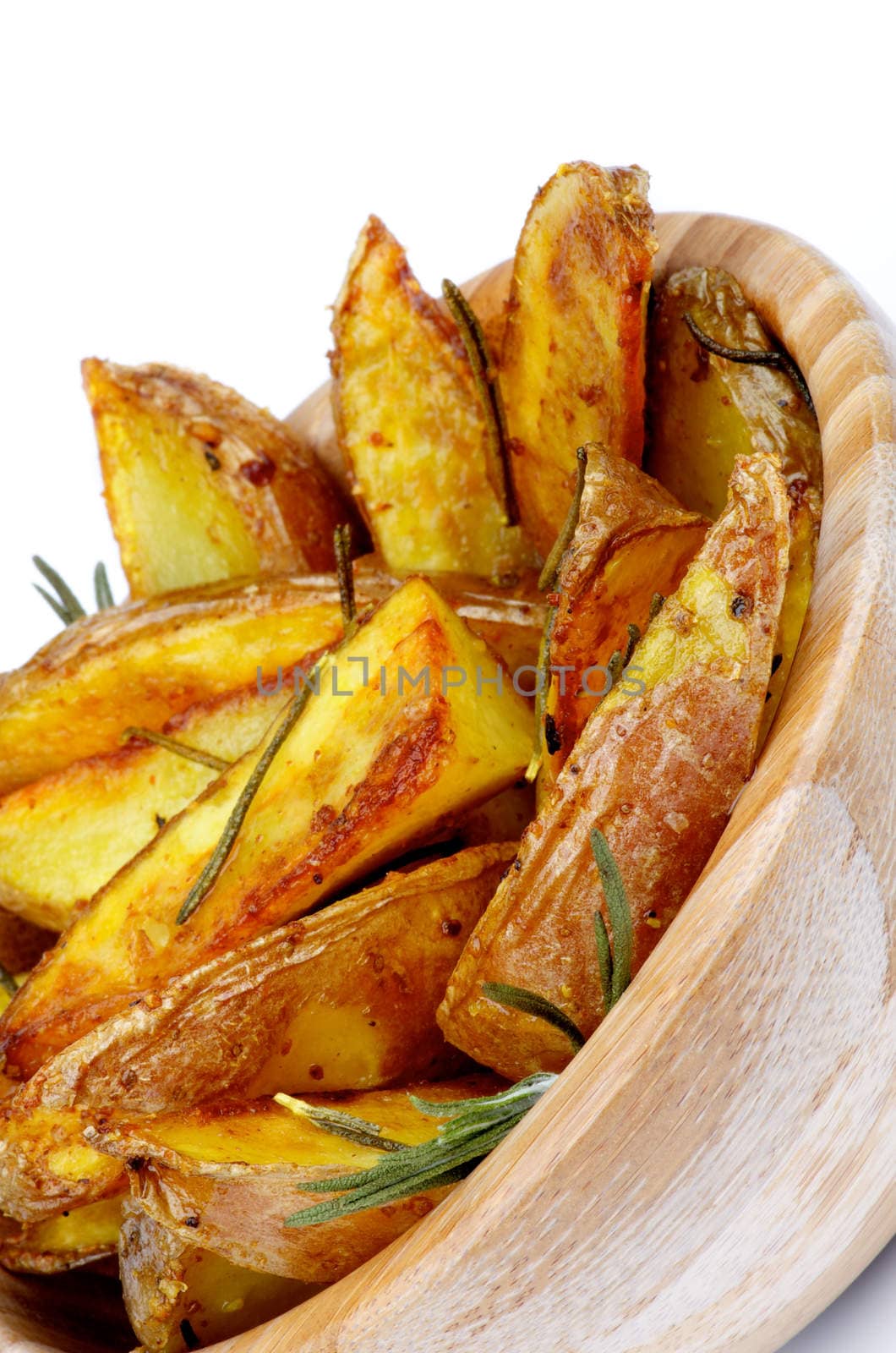 Delicious Roasted Potato Wedges with Rosemary and Spices in Wooden Bowl Cross Section on White background