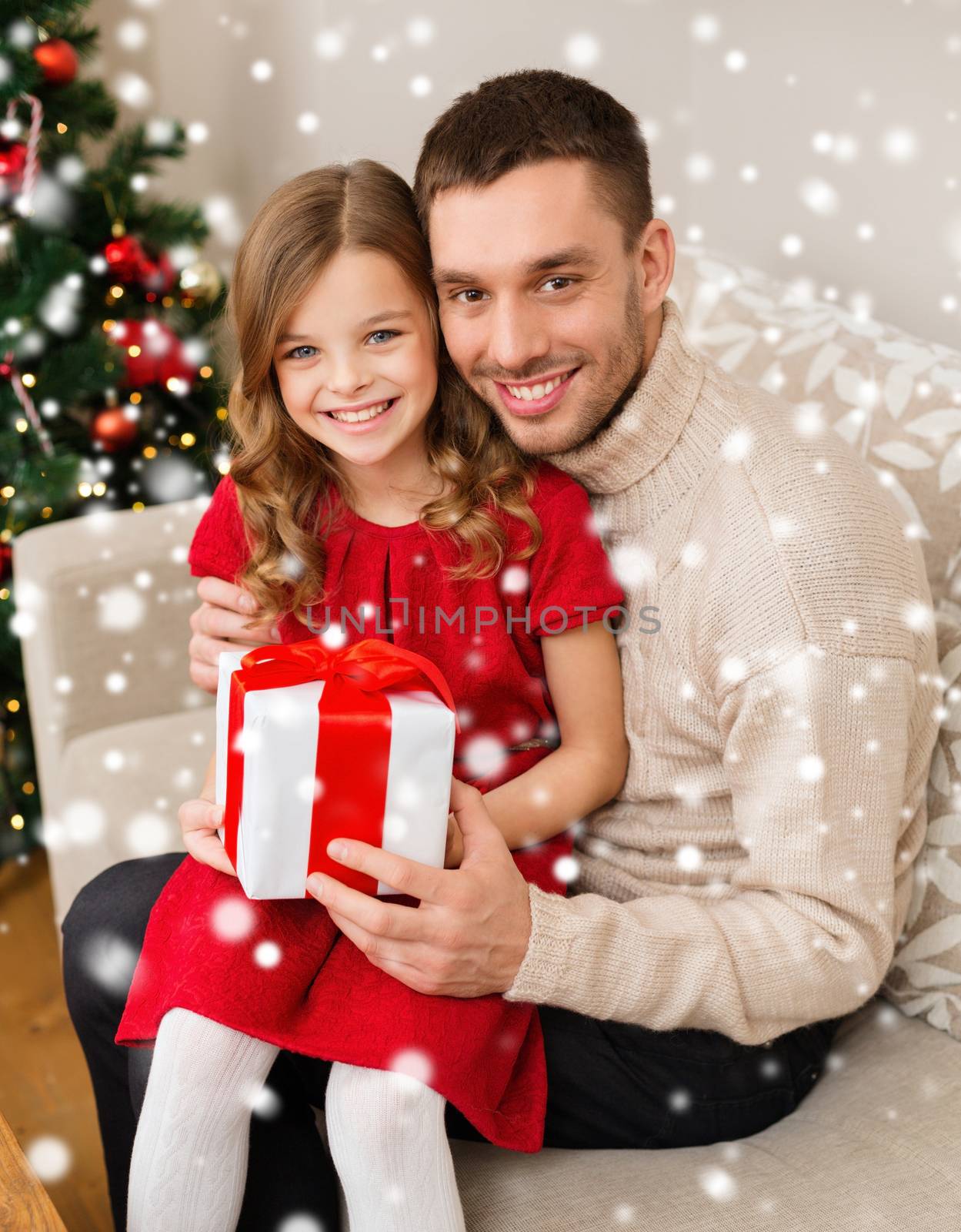 christmas, holidays, family and people concept - smiling father and daughter holding gift box and hugging at home