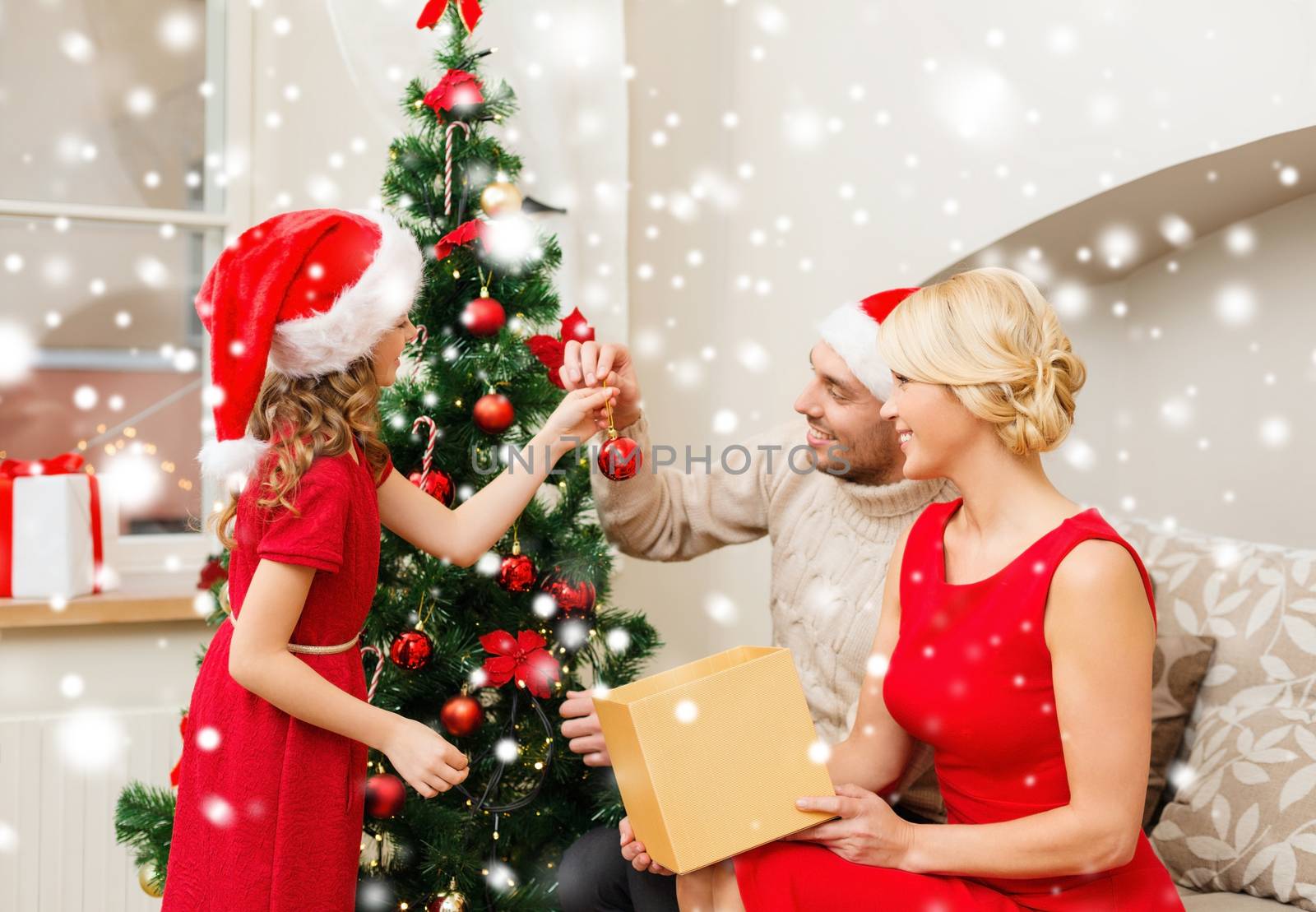 smiling family decorating christmas tree at home by dolgachov