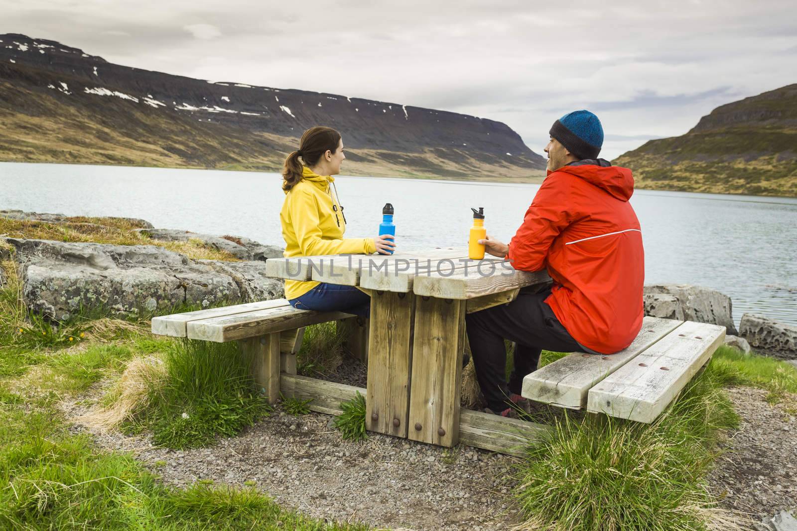 A couple resting close to a beautiful lake