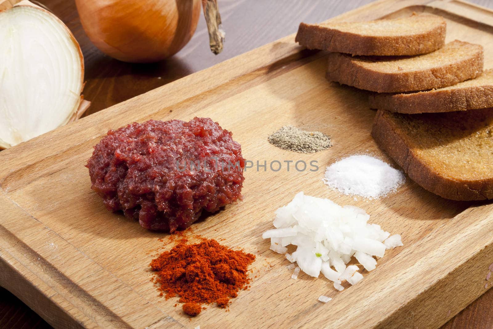 Steak tartar with the fried bread on the wooden trencher