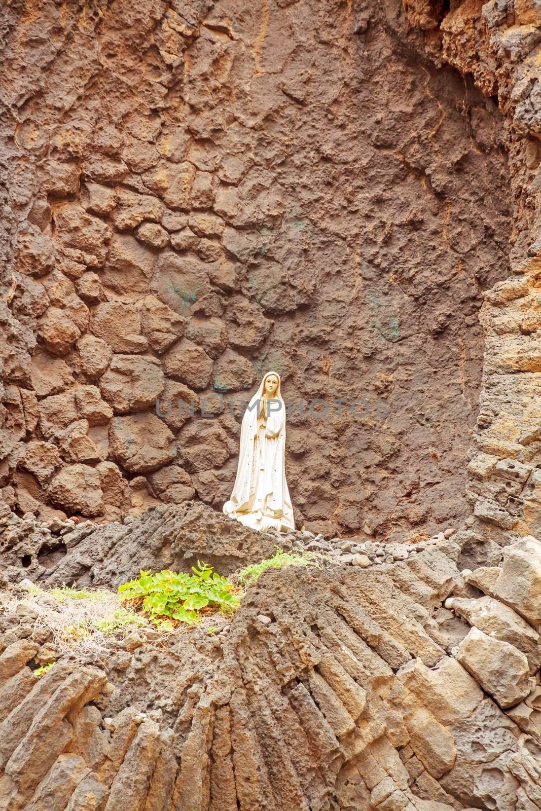 Praying Madonna in front of rock wall in Ribeira da Janela, Madeira, Portugal