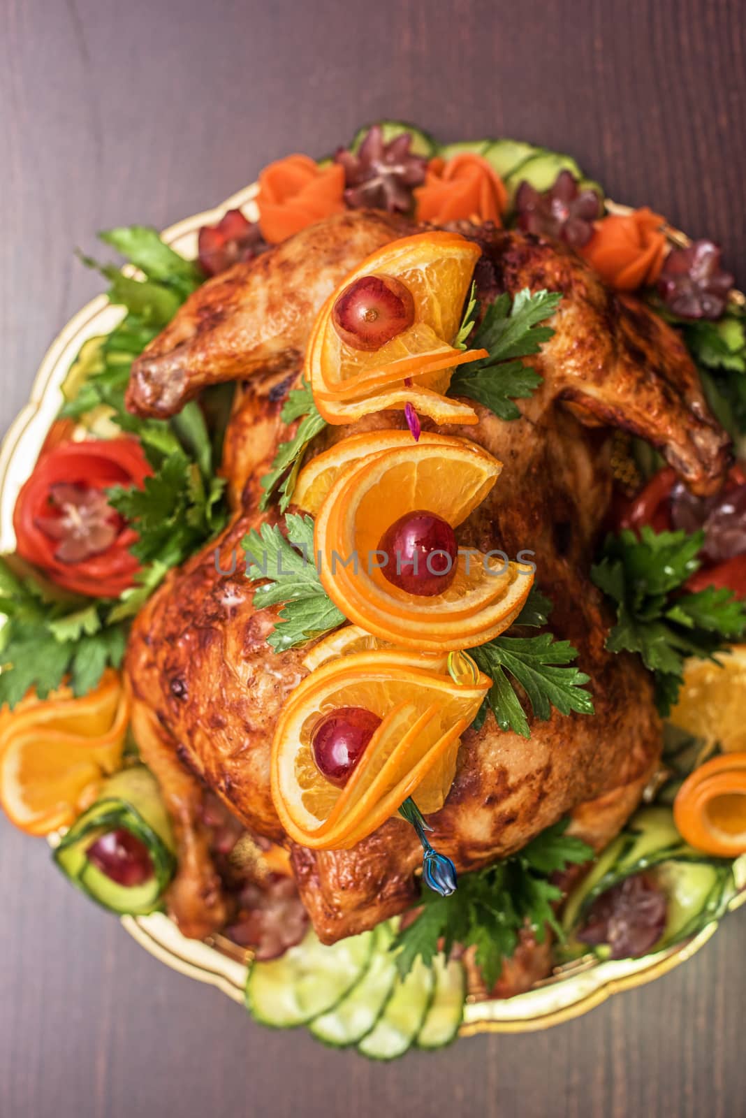 Whole roasted chicken with vegetables and fruits on wooden table