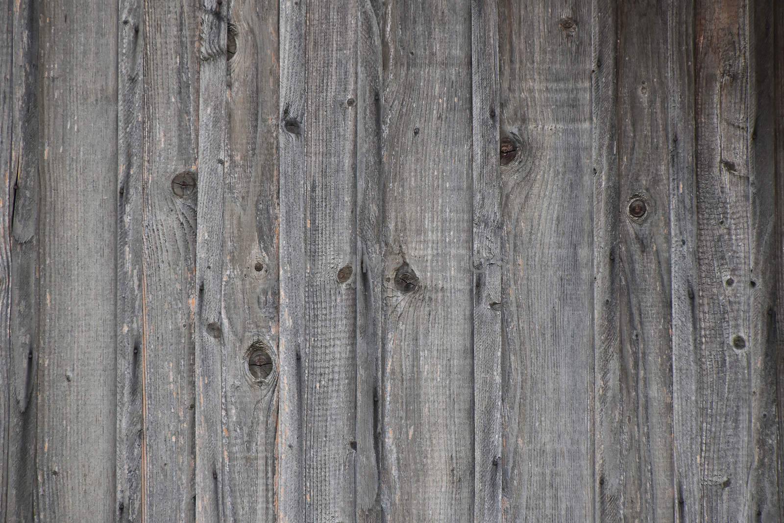 Old dark vintage rustic aged antique wooden sepia fence panel with vertical gaps, planks and chinks