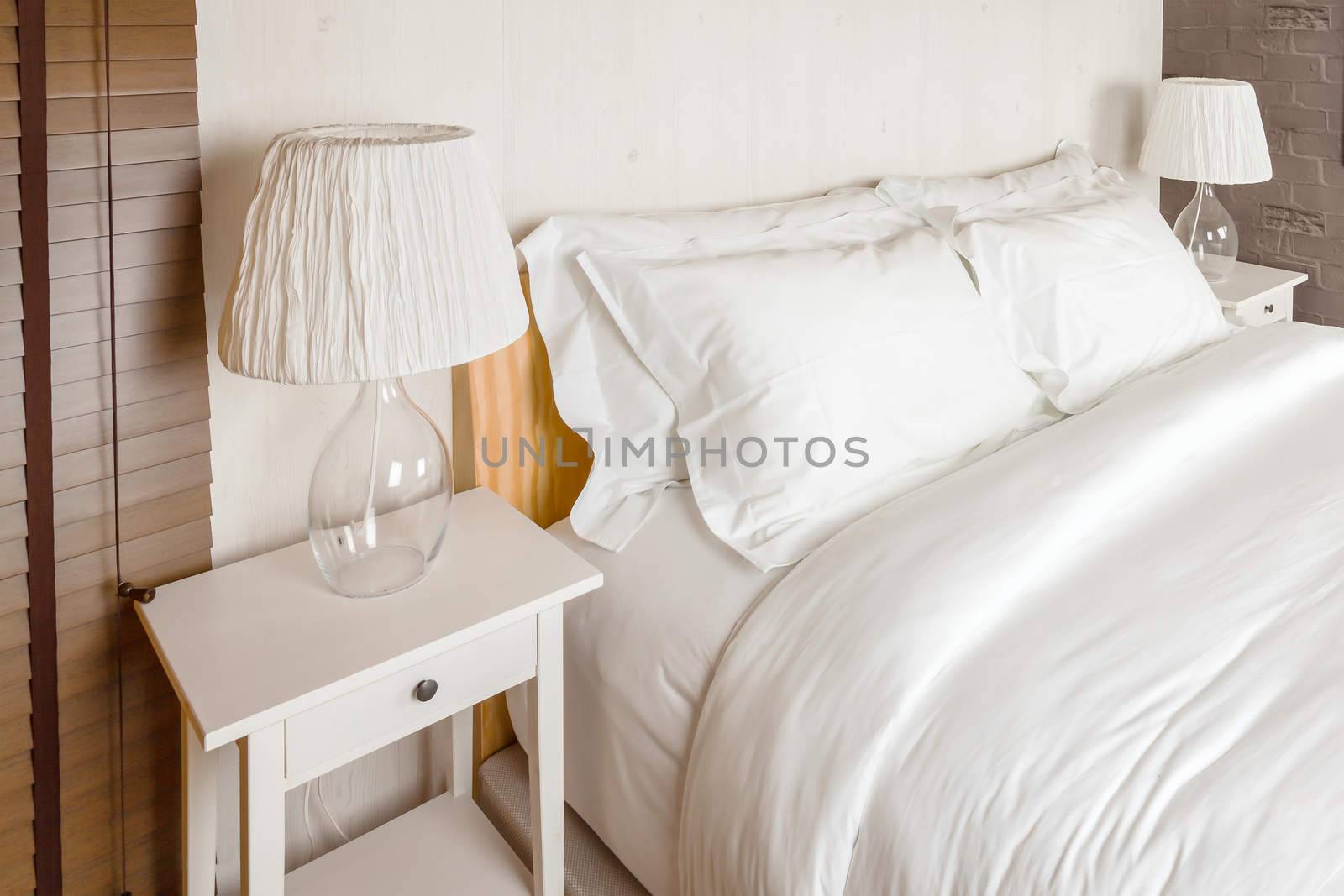 two pillow on bedroom with white bed sheet and lamp by FrameAngel