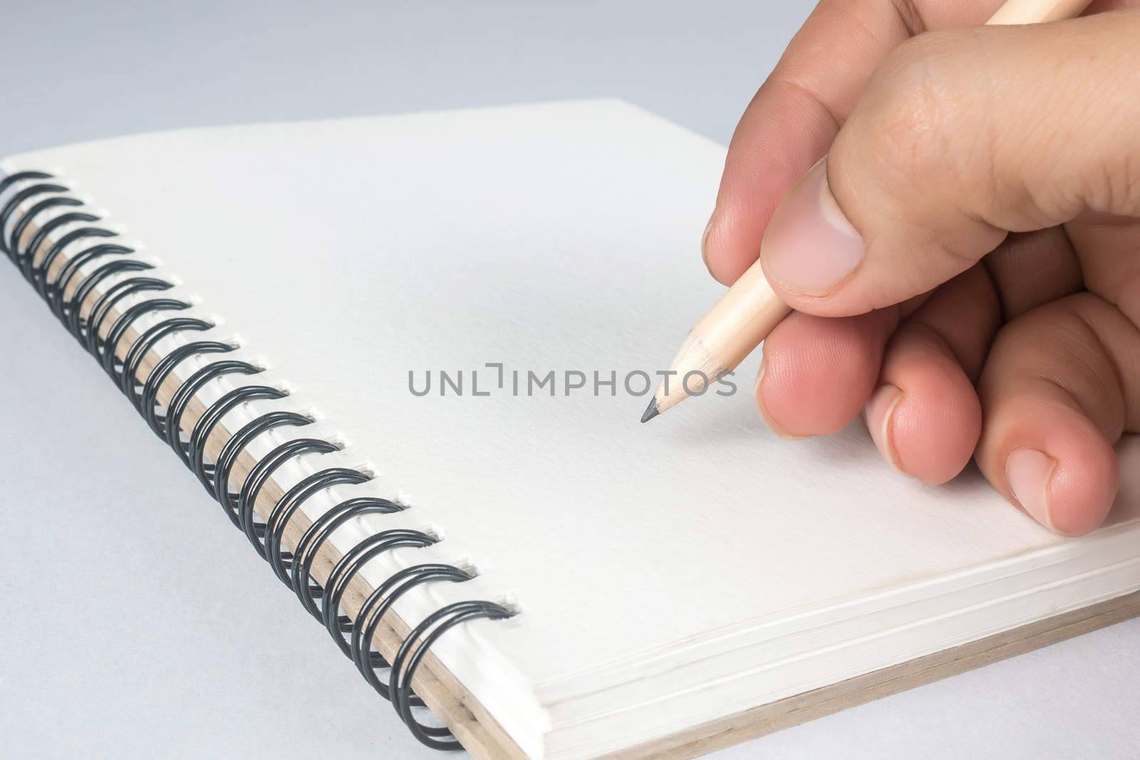 writing with pencil on notebook