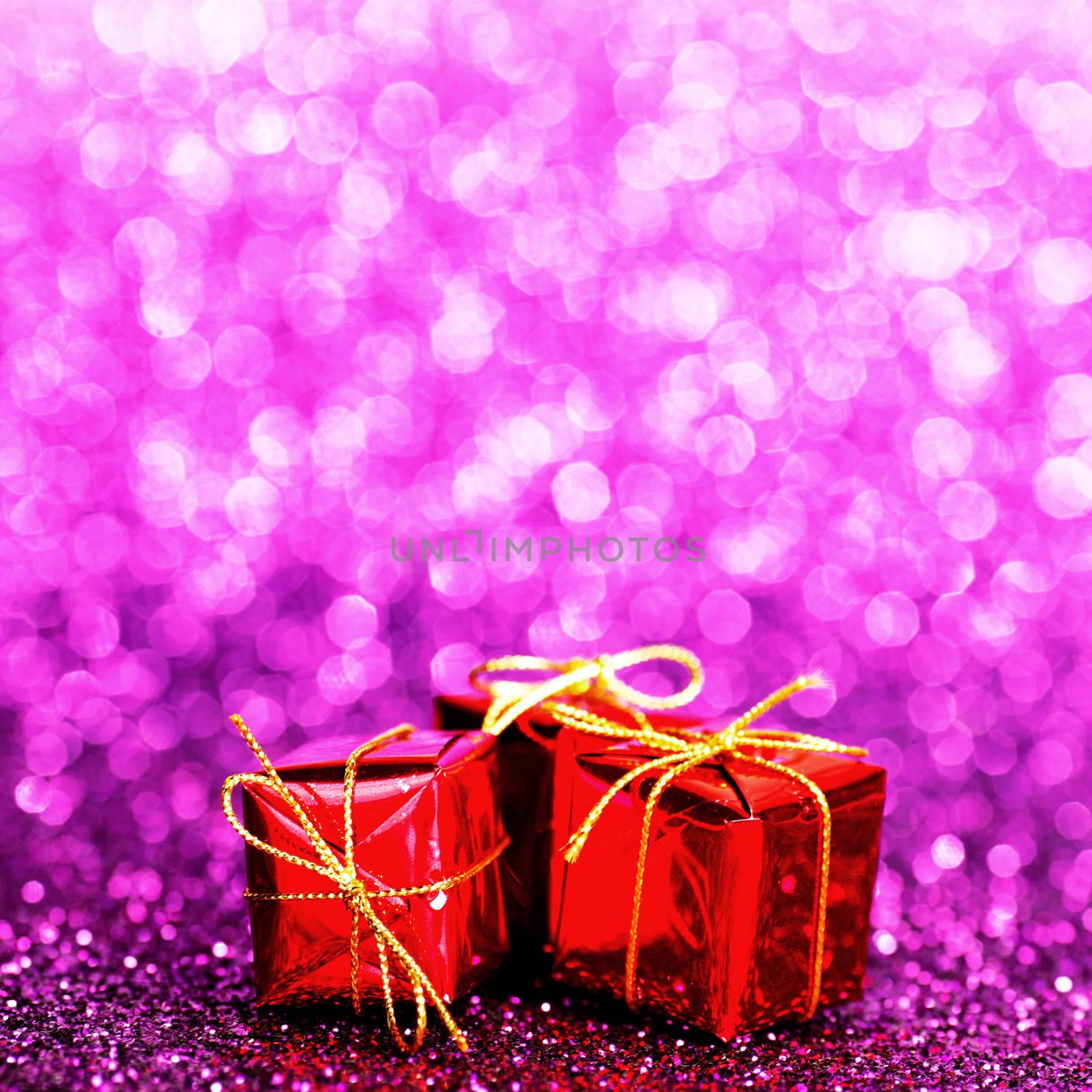 Decorated red holiday gifts on glitter background