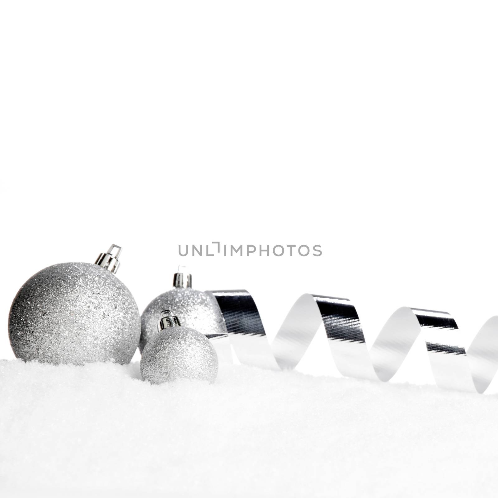 Beautiful various silver christmas decor on snow close-up