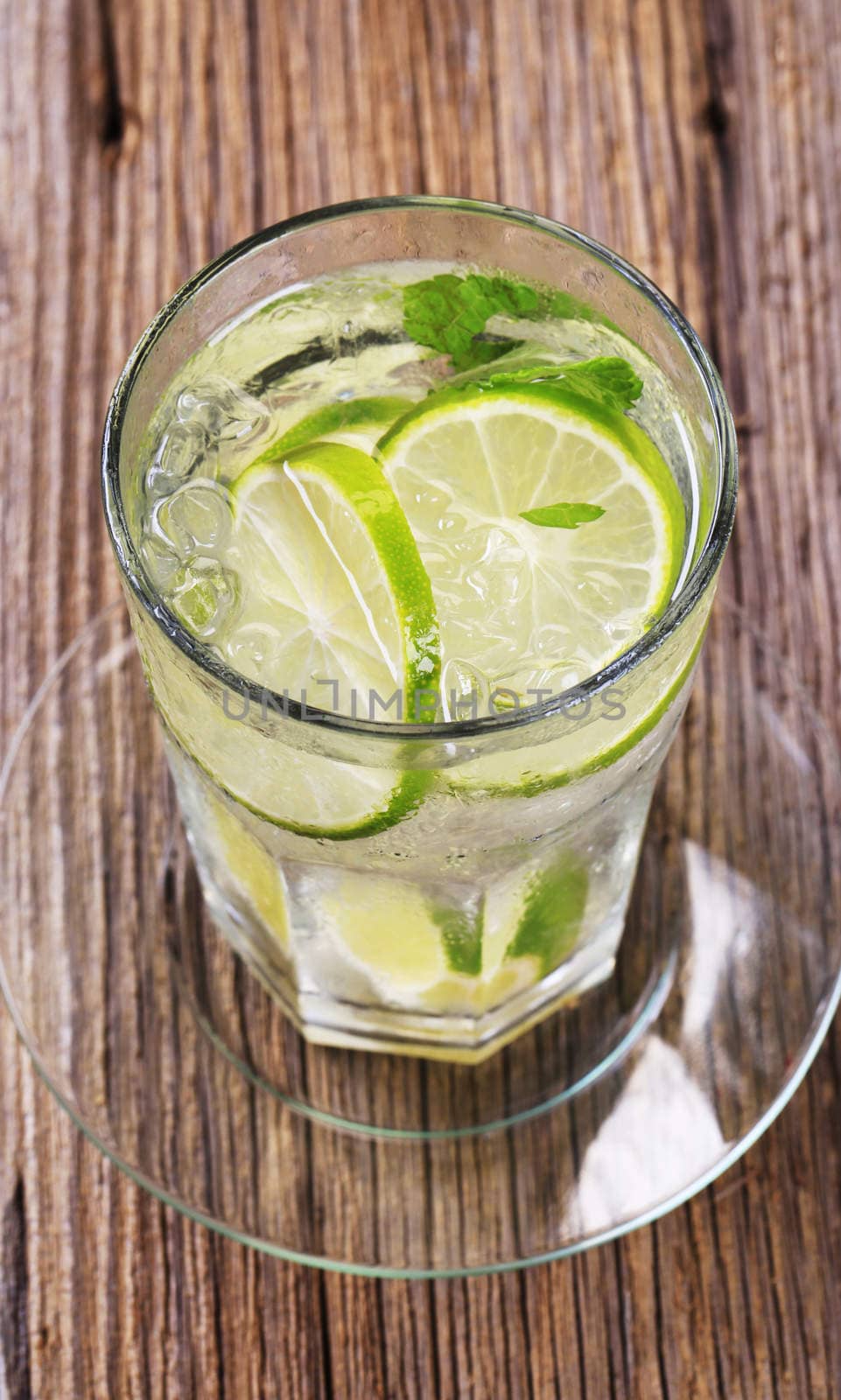 Glass of cold drink with slices of lime
