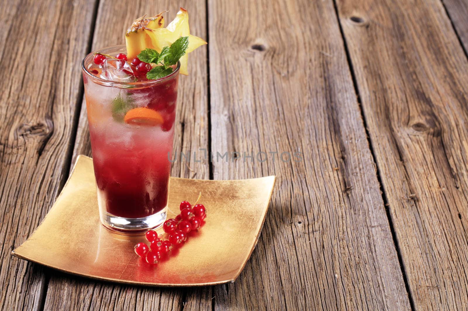 Glass of iced drink garnished with fresh fruit