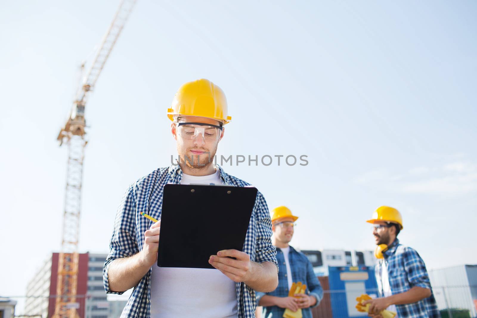 group of builders in hardhats outdoors by dolgachov