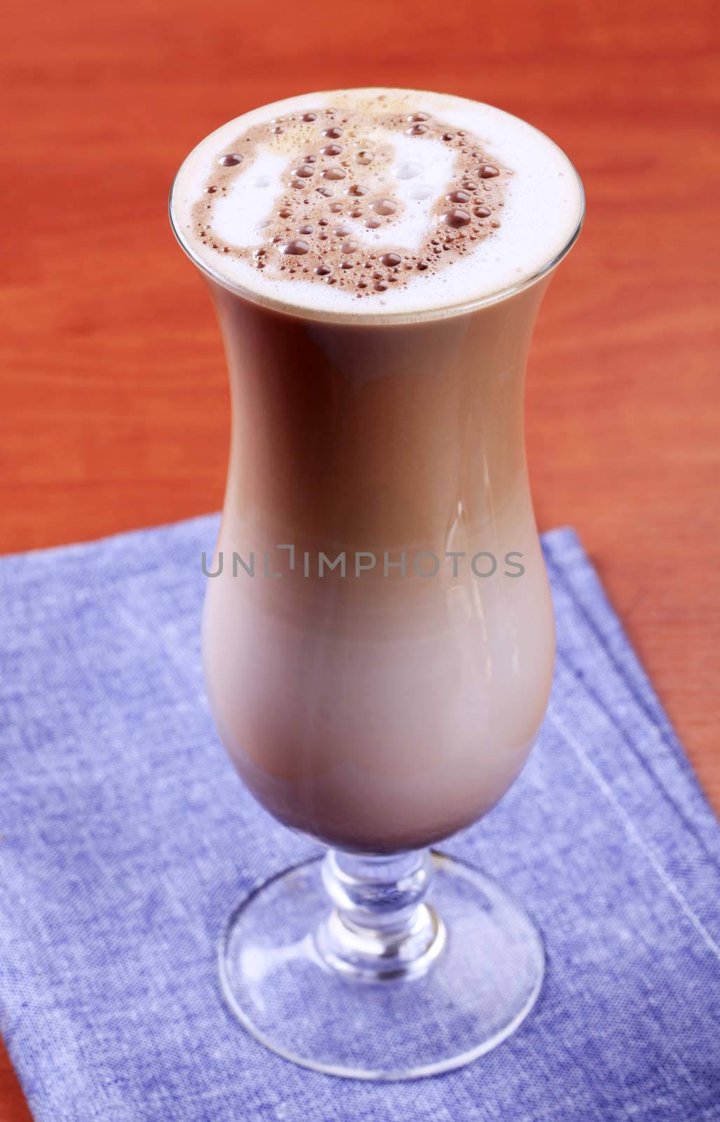 Chocolate drink with milk froth in tall glass