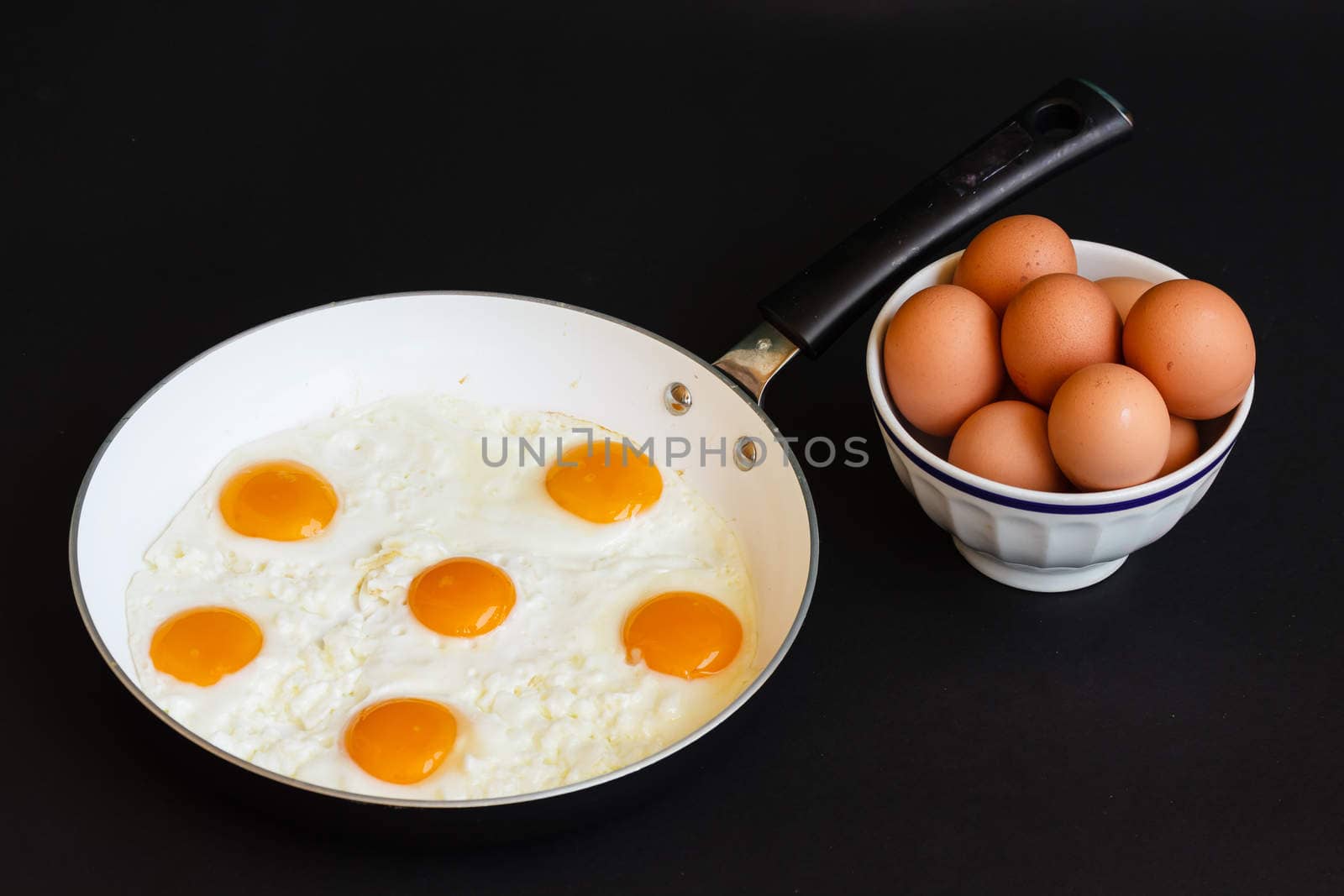 fried eggs in frying pan by moorea