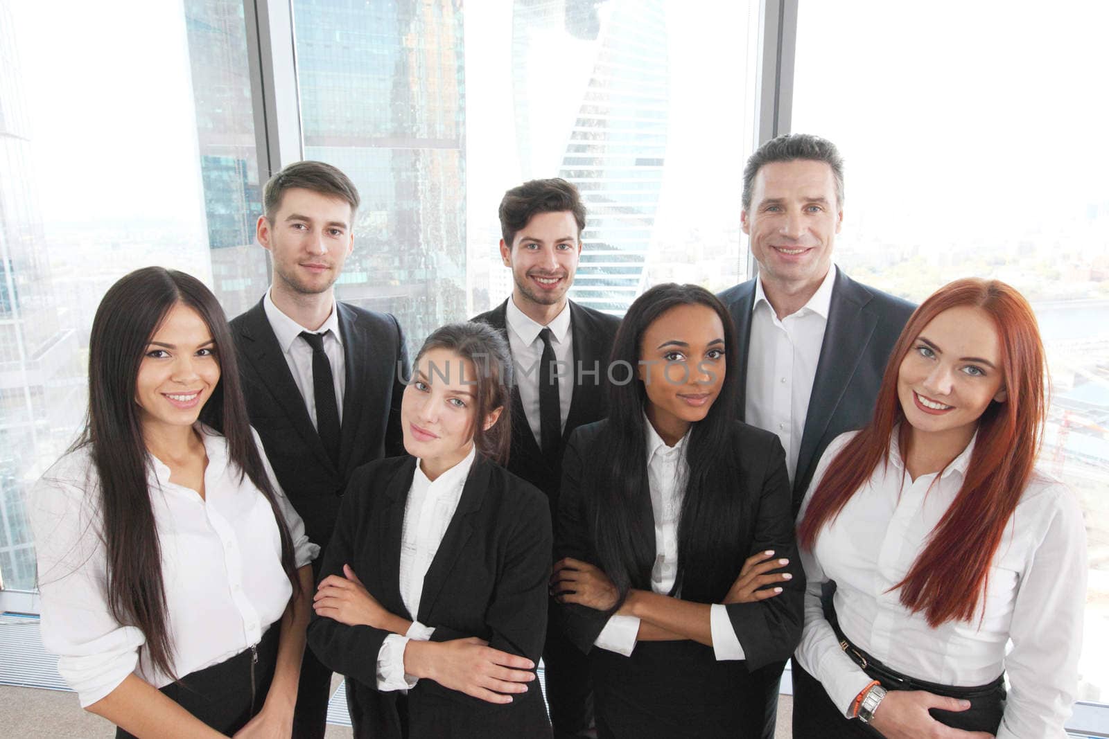 Portrait of business team of men and women in office with view on skyscrapers