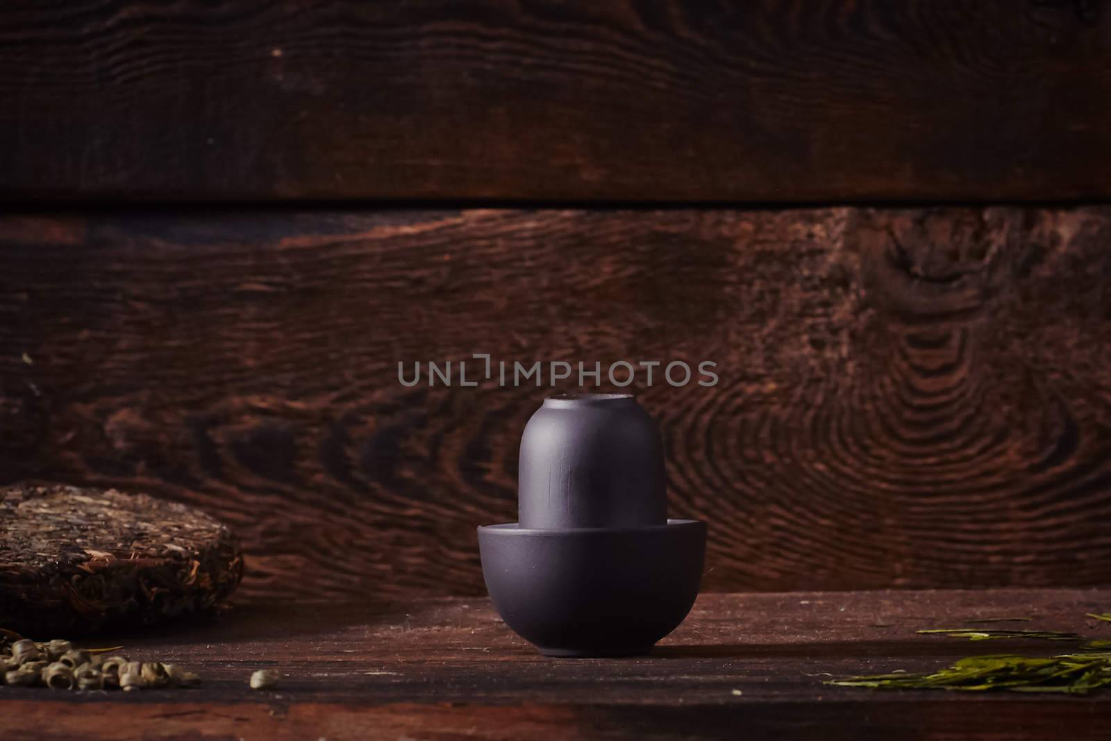 Ceramic tea cup, loose tea leaf on wood table