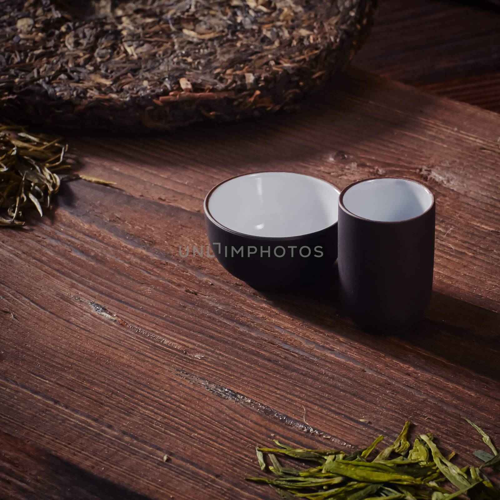 Ceramic tea cup, loose tea leaf on wood table