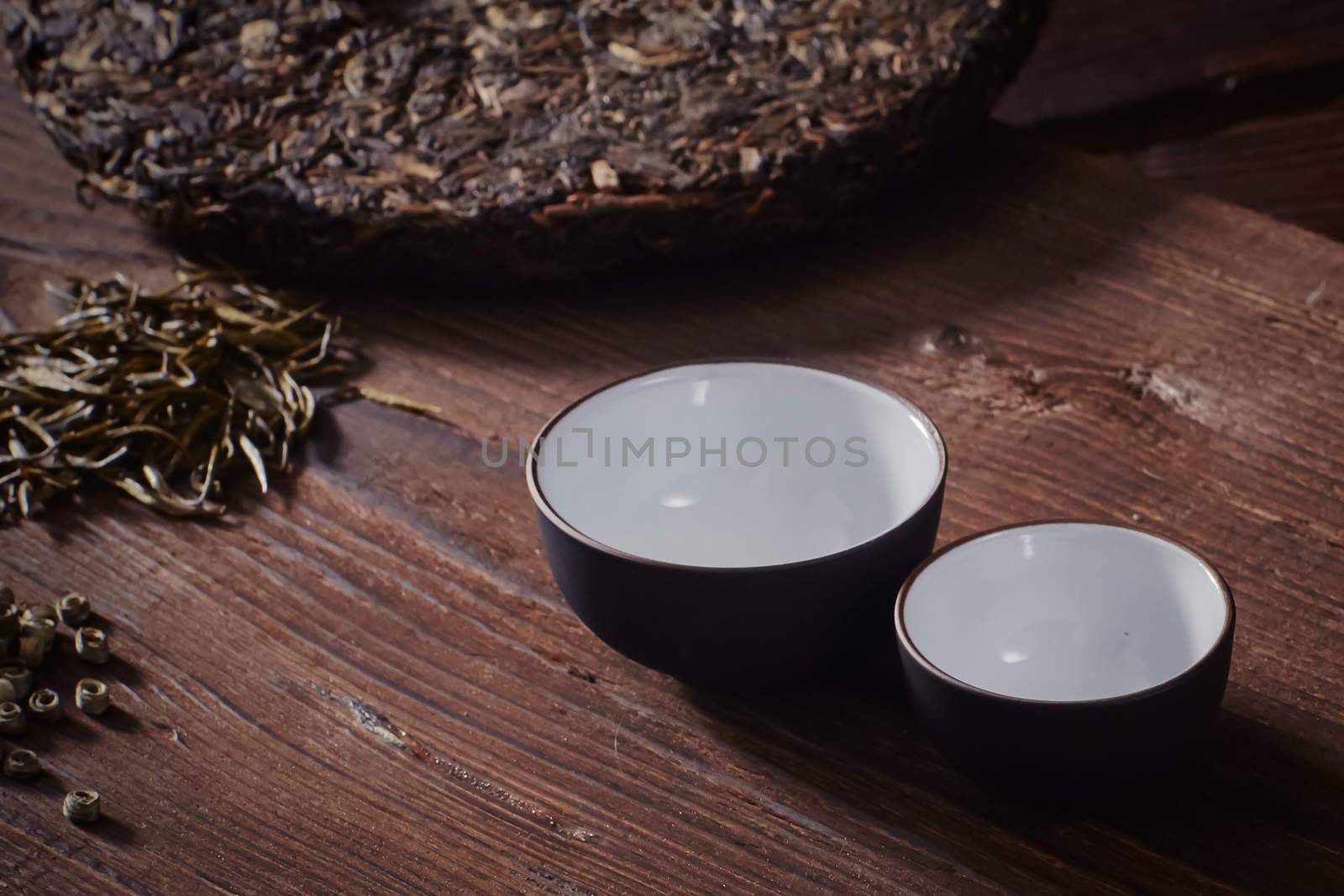 Ceramic tea cup, loose tea leaf on wood table