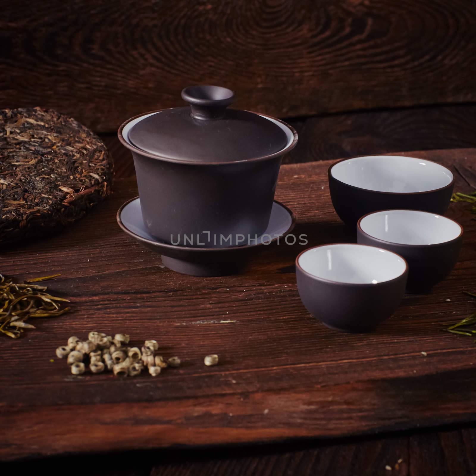 Ceramic tea cup, loose tea leaf on wood table