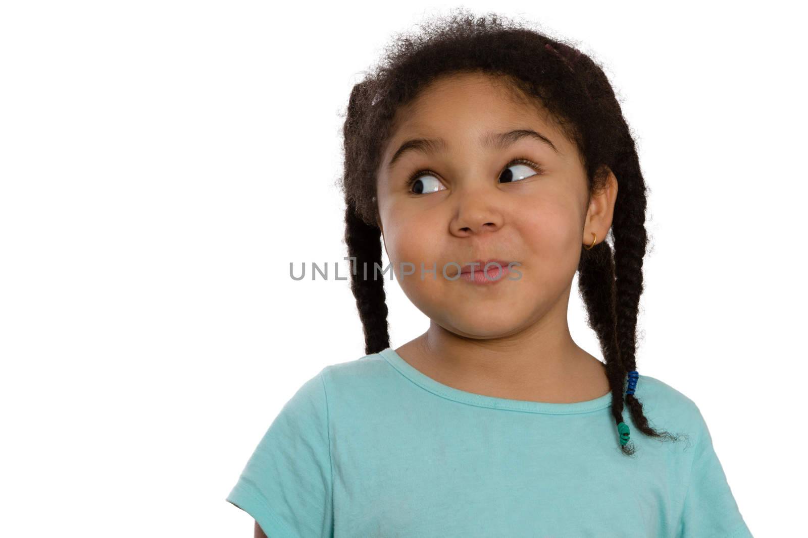 Charismatic little African American girl looking sideways with a cute knowing smile and speculative look, head and shoulders isolated on white with lateral copyspace