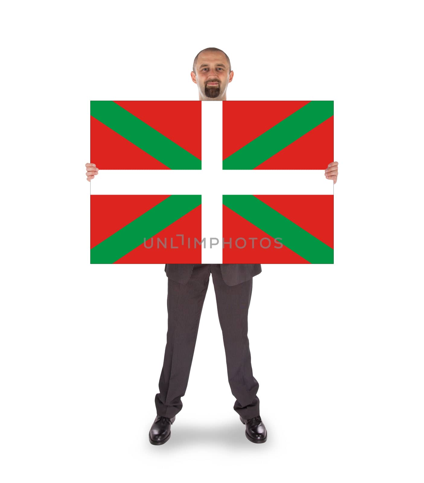 Smiling businessman holding a big card, flag of Basque Country, isolated on white