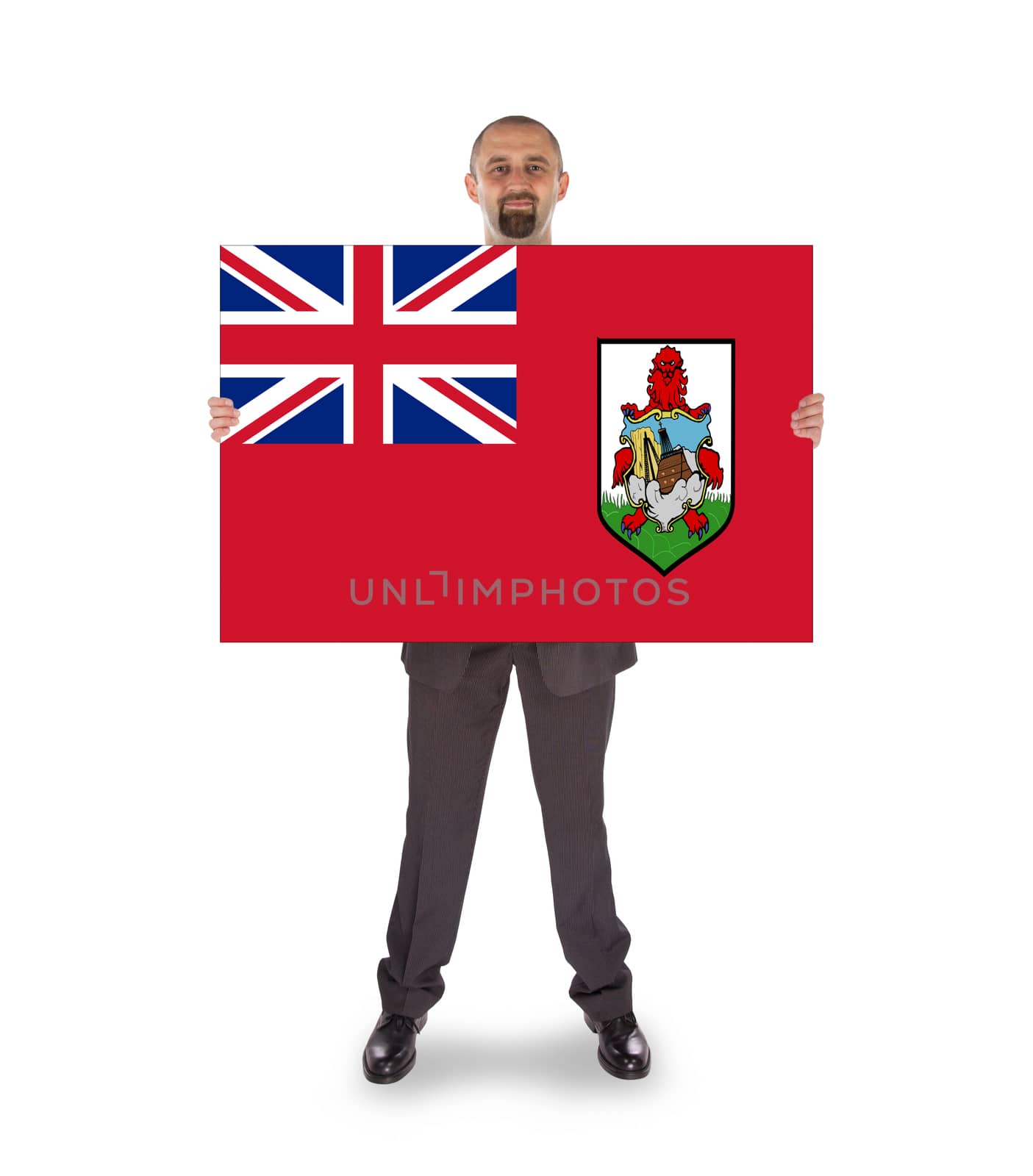 Smiling businessman holding a big card, flag of Bermuda, isolated on white