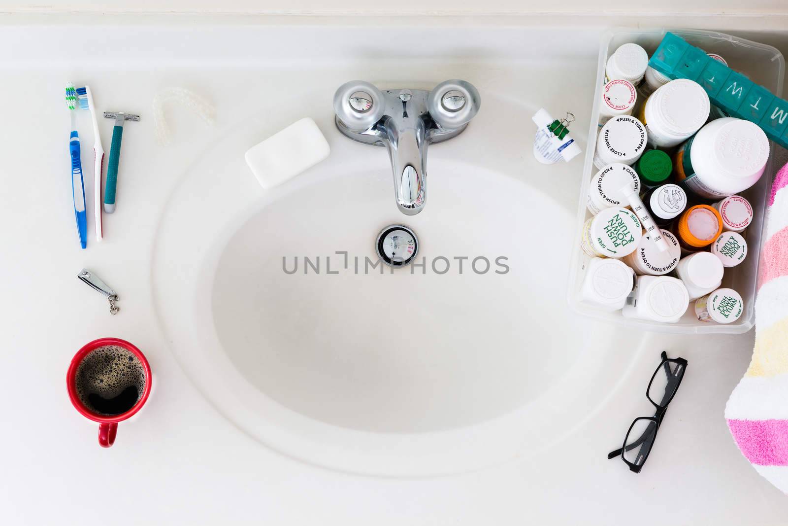 Elderly domestic bathroom sink with medicines and coffee in the morning
