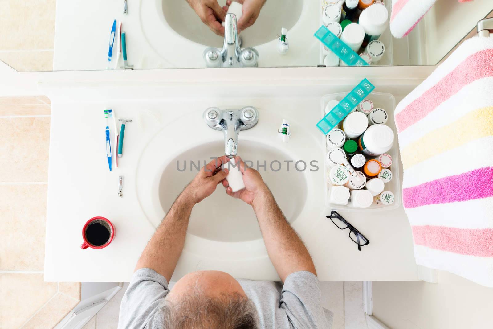Overhead view of Man washing his hands at the sink before his day starts