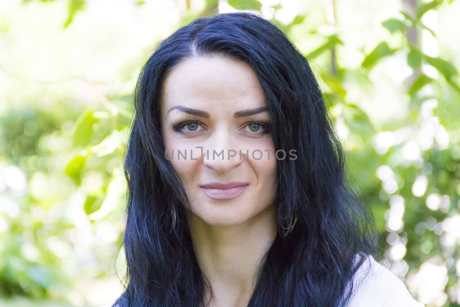 European woman with black hair on green background