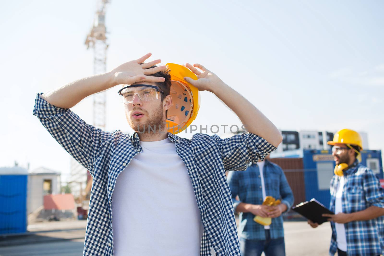 group of builders in hardhats outdoors by dolgachov