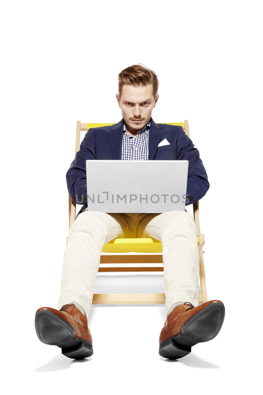 Young man sitting on a sunbed and doing a business case. Isolated on white background. 