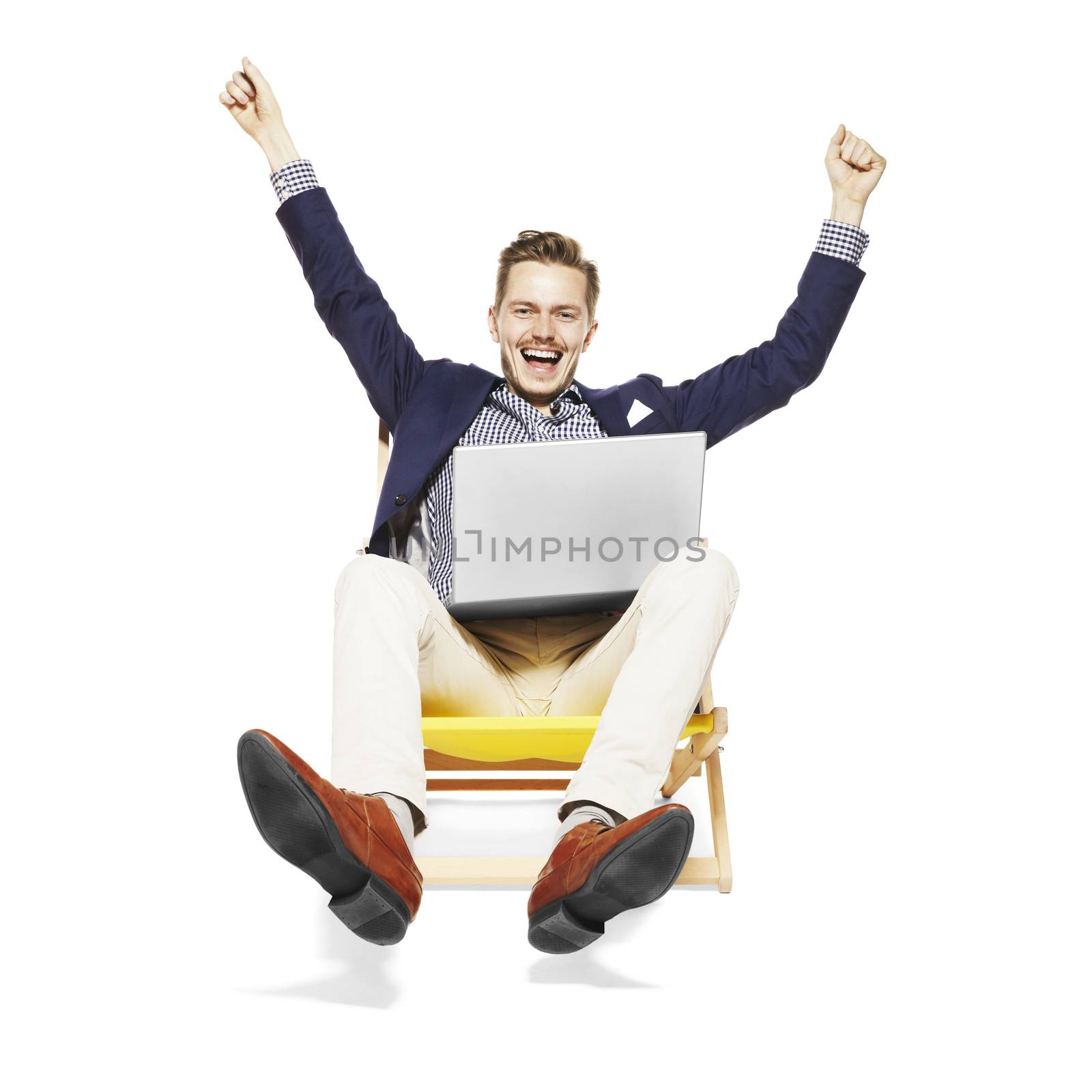 Studio shot of young man jumps for joy while sitting on a sunbed. Isolated on white background. 