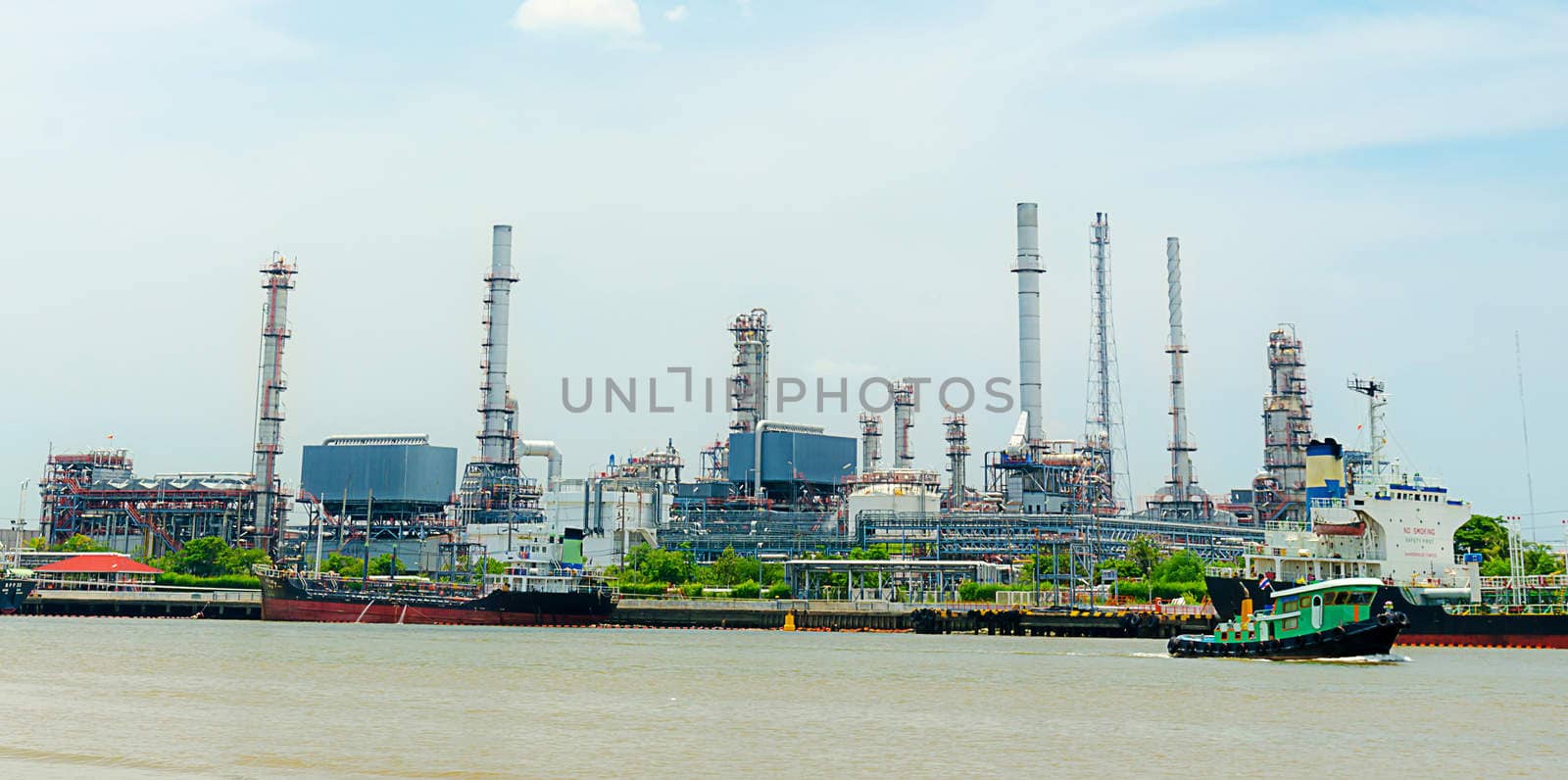 Oil refinery reflected on river. Panoramic images