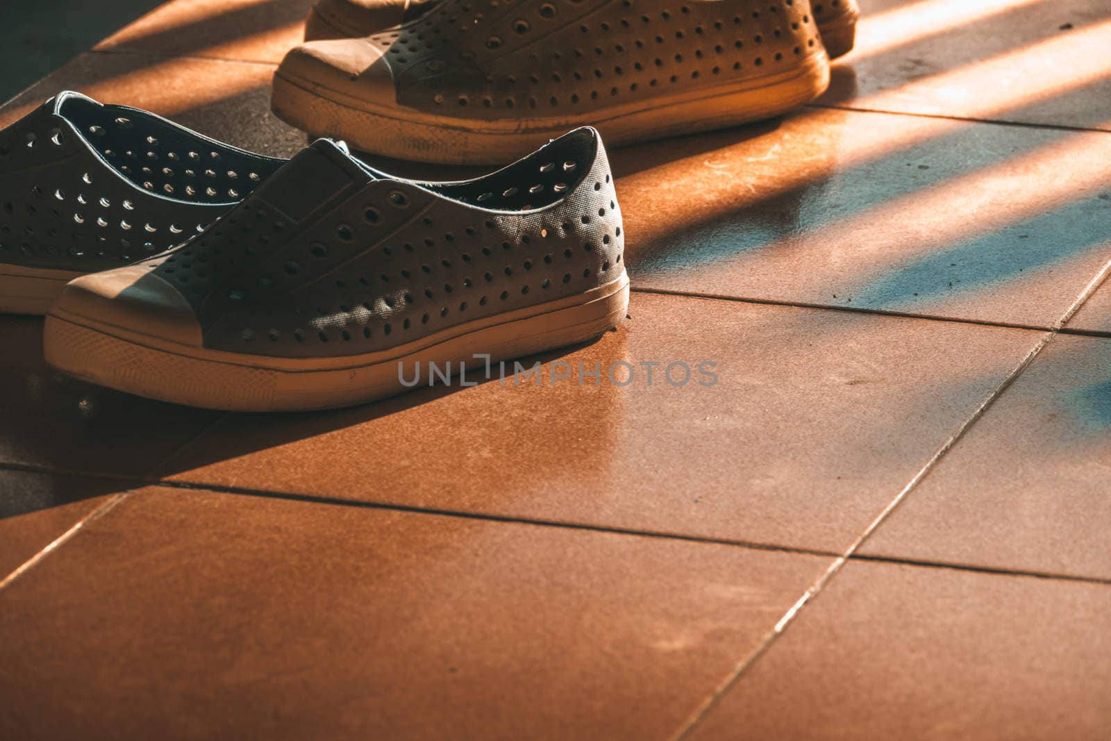 Plastic shoes on tile background with copy space, abstract background