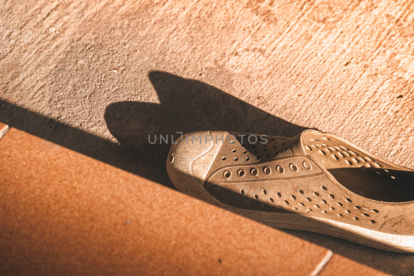 Plastic shoes on tile background with copy space by teerawit