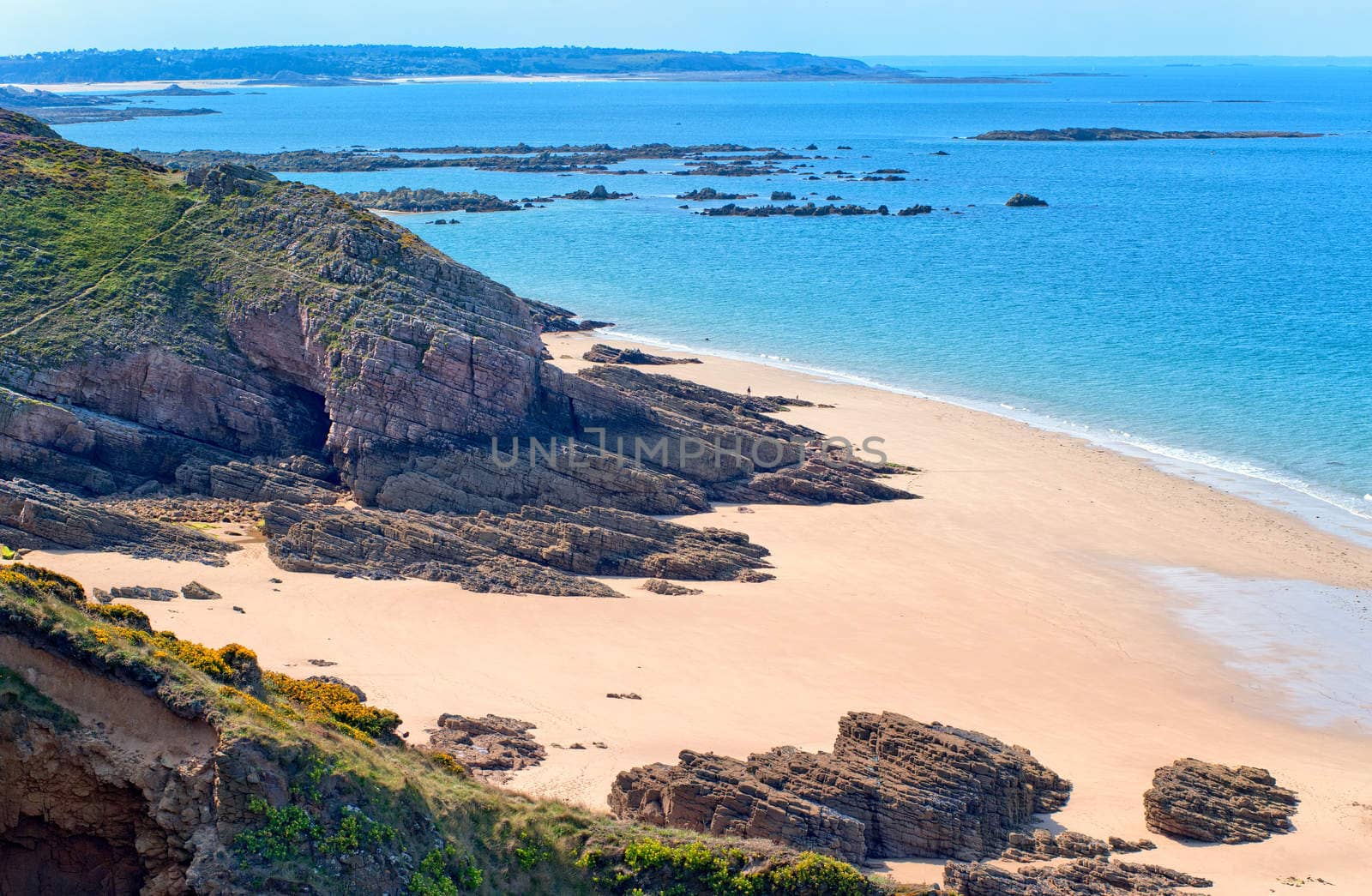 Dark rocks on a sand beach at atlantic coast Cote de Granite Rose in Brittany, France