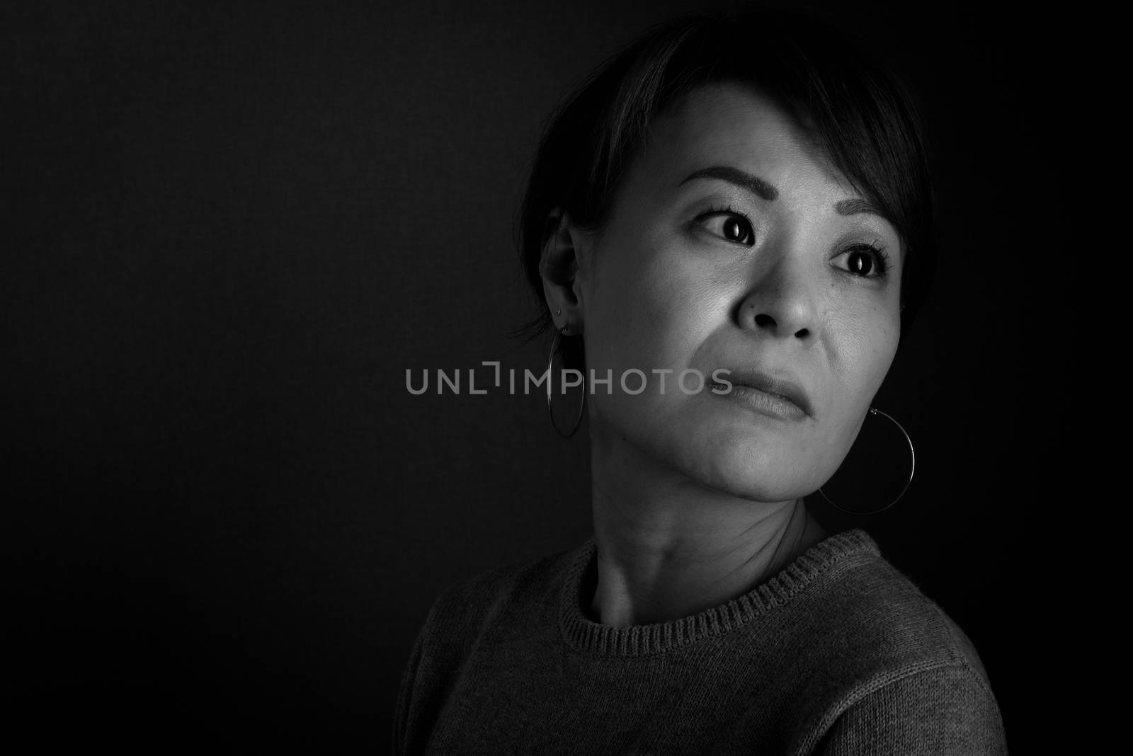 A black and white headshot of a sad looking middle aged Japanese woman.