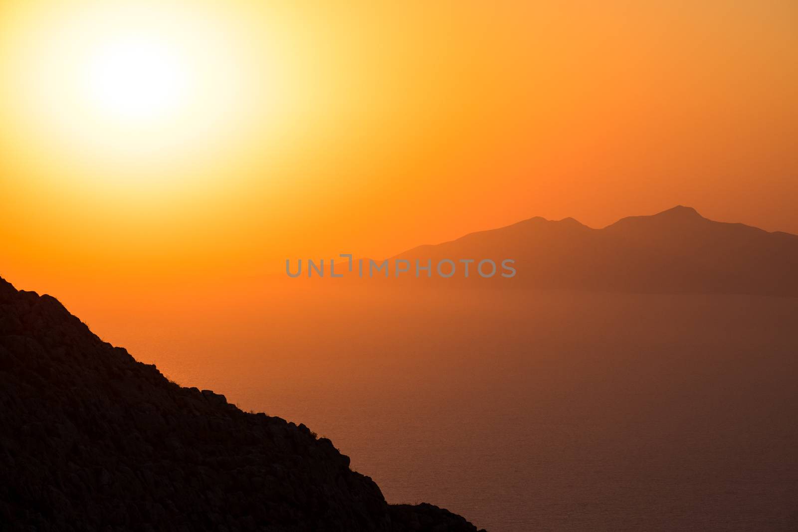 Landscape view of beautiful colorful sunrise above the ocean with horizon and distant islands, Santorini, Greece