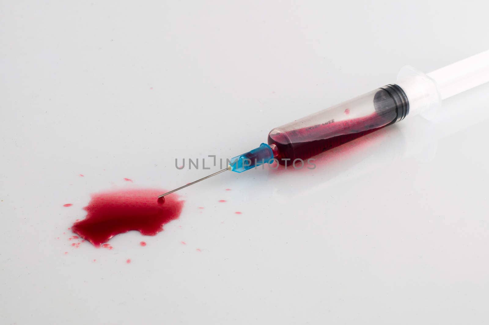 Syringe with blood on withe background